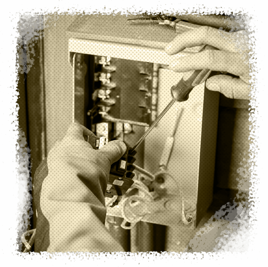 Hands working on an electrical panel with a screwdriver, focusing on installing or repairing components related to generator transfer switches and interlocks for reliable power solutions in Houston, TX.