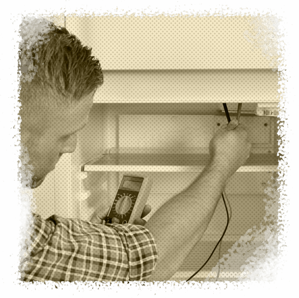 Electrician using a multimeter to conduct electrical safety inspection inside a refrigerator, emphasizing professional electrical services in Houston, TX.