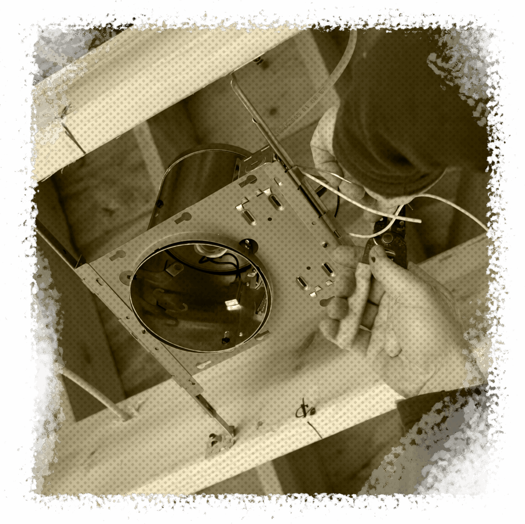 Electrician installing a recessed lighting fixture in a ceiling, demonstrating professional lighting installation services for homes in Houston, TX.