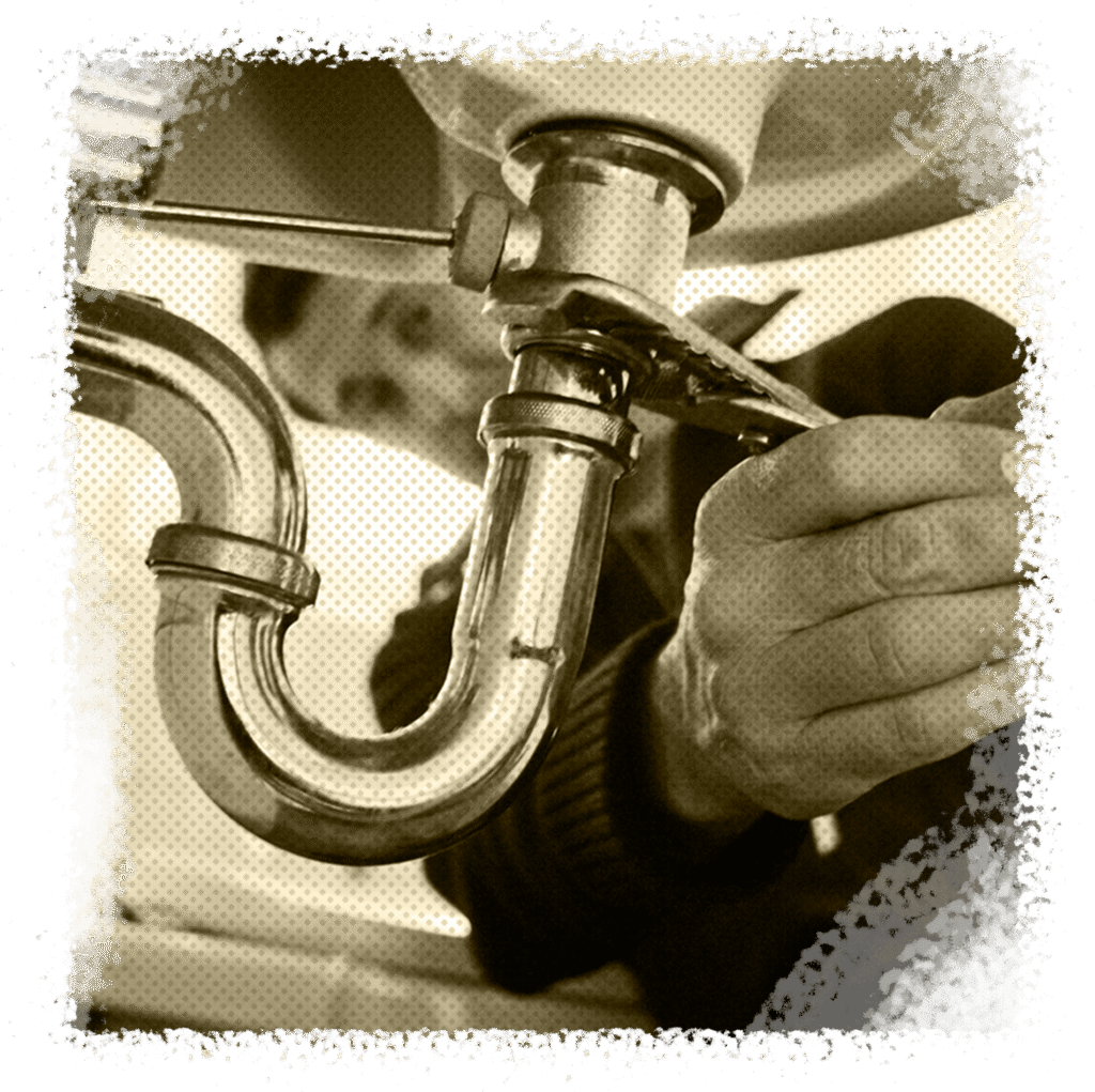 Plumber repairing a pipe under a sink, showcasing expertise in plumbing services for pipe repairs in Houston, TX.