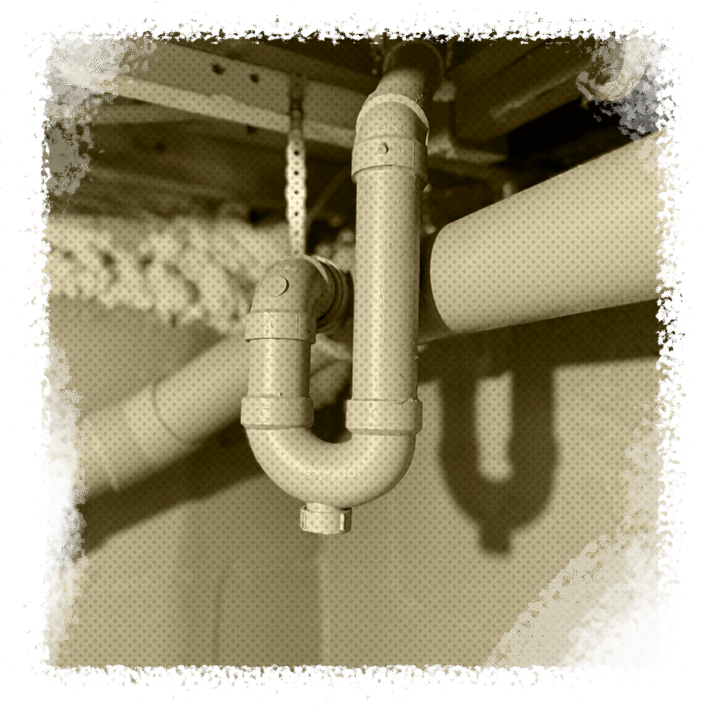 Sewer pipe system in residential setting, highlighting plumbing components relevant to sewer replacement and repair services in Houston, TX.
